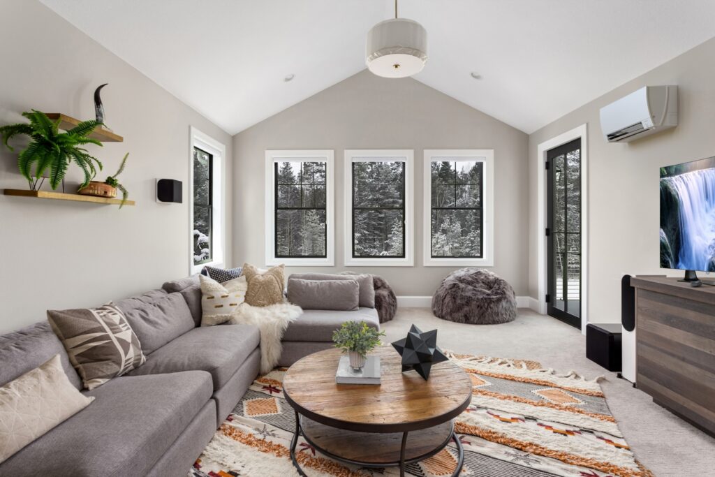 Comfortable living room with a ductless HVAC head unit on the wall with winter weather outside of the windows