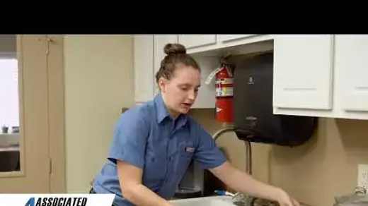 Associated Heating & Air Conditioning technician cleaning a Daikin air filter