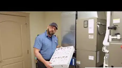 Associated Heating & Air Conditioning Tech showing how to replace a furnace filter