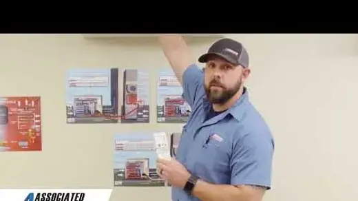 Associated Heating & Air Conditioning technician showing how to use a ductless system remote