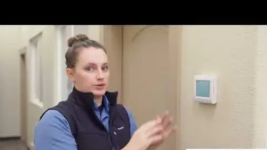 Associated Heating & Air Conditioning technician showing how to use a smart thermostat